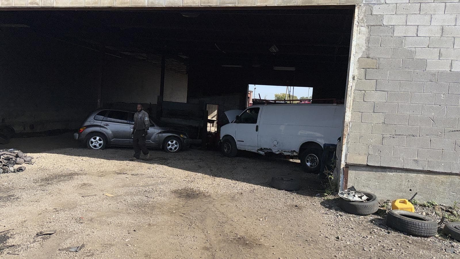 Vehicles inside an open service bay at the Detroit Junk Car Recycling yard